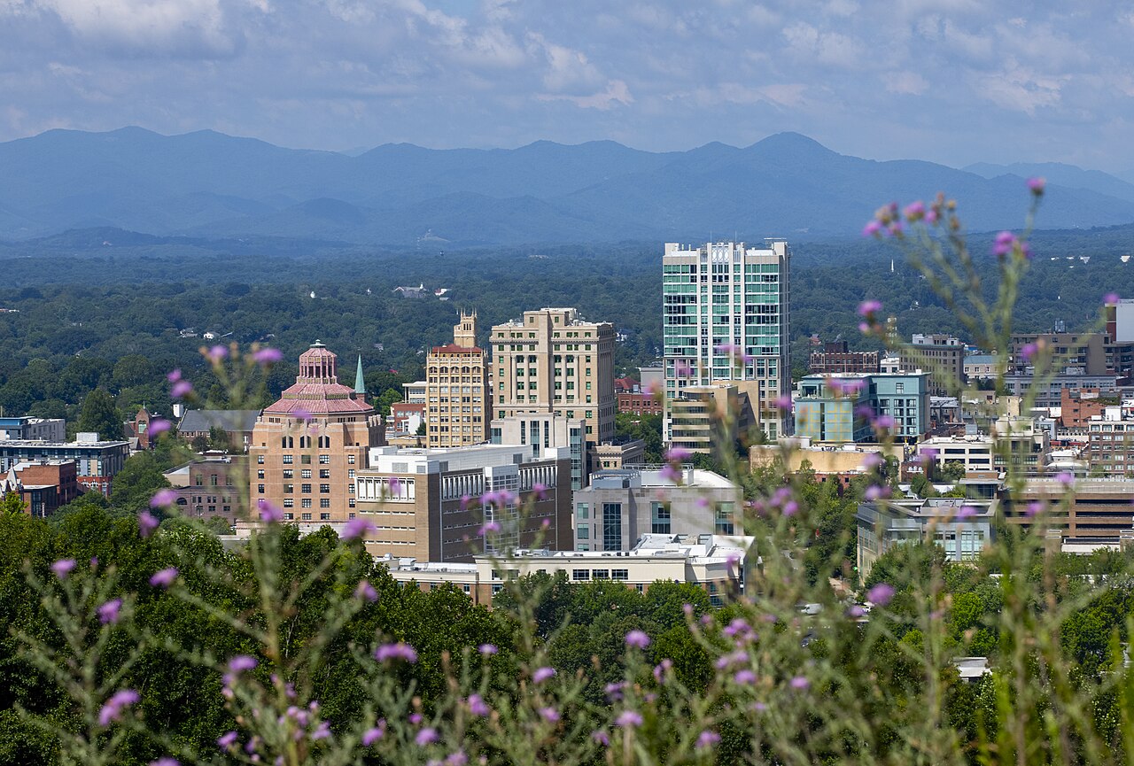 Downtown Asheville with the Blue Ridge Mountains behind the city, photographed in July 2023.