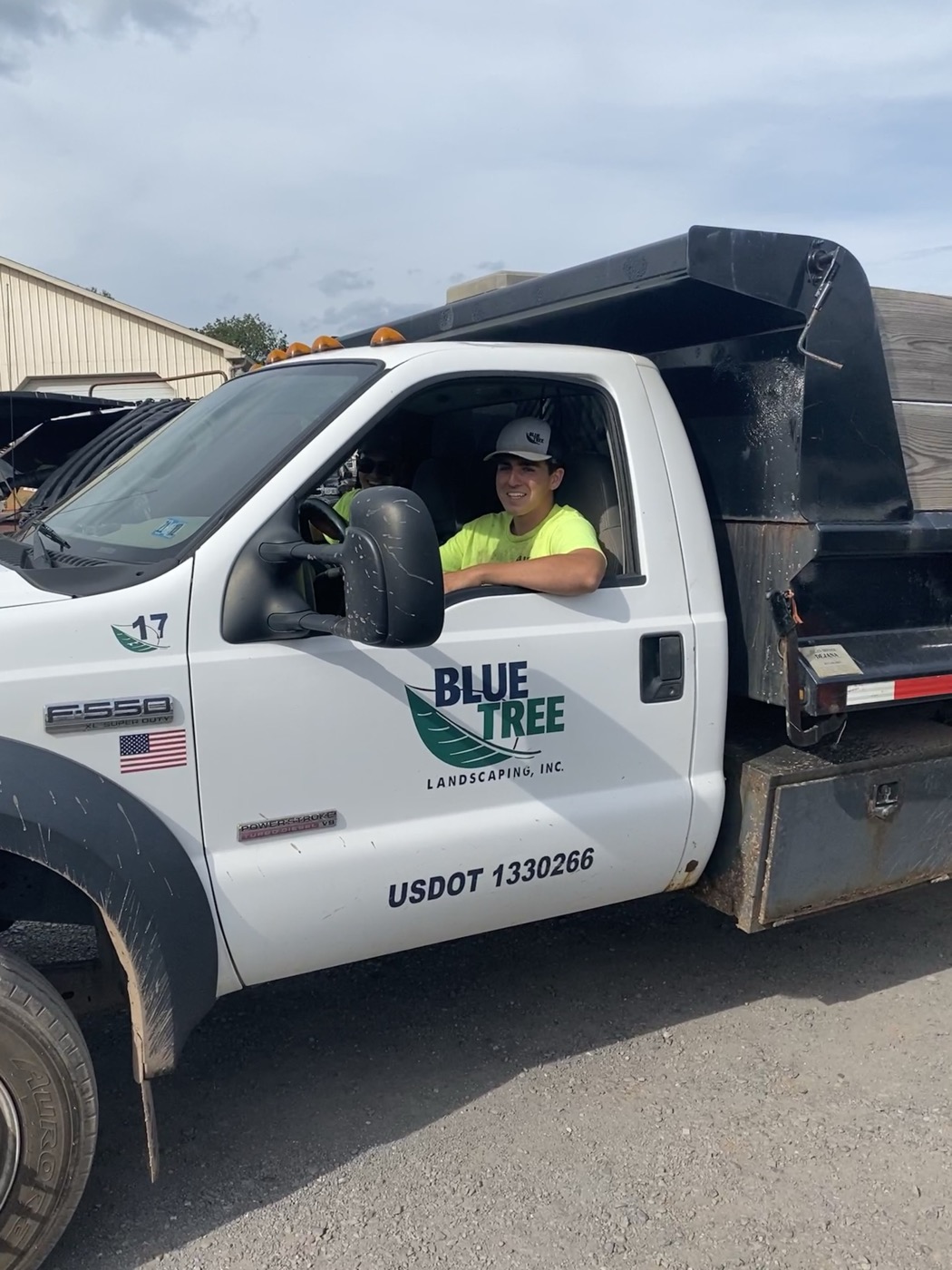 A Blue Tree crew member in a branded Ford F-550 dump truck